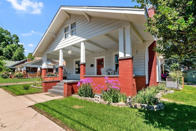 view of front facade featuring covered porch and a front yard