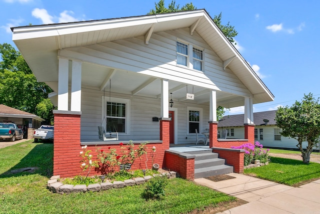 view of front of property with covered porch and a front lawn