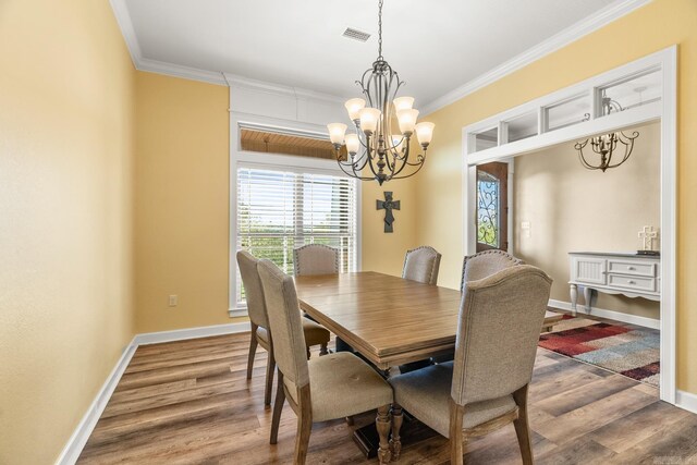 dining room with dark hardwood / wood-style flooring, an inviting chandelier, and ornamental molding