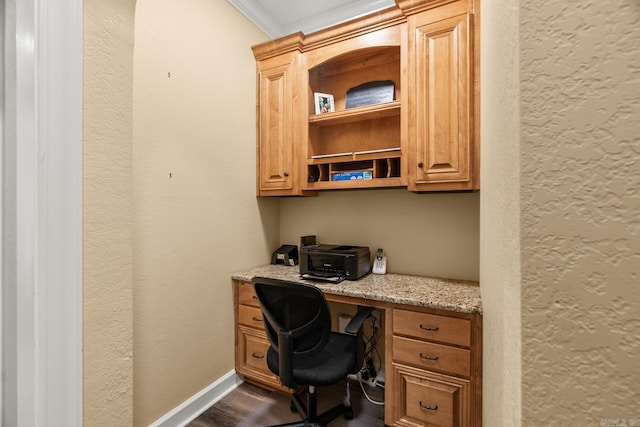 office area with dark hardwood / wood-style flooring, built in desk, and crown molding