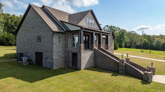 view of side of property with central AC unit and a yard