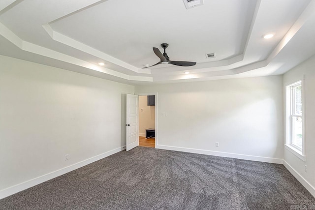 carpeted empty room featuring ceiling fan and a tray ceiling