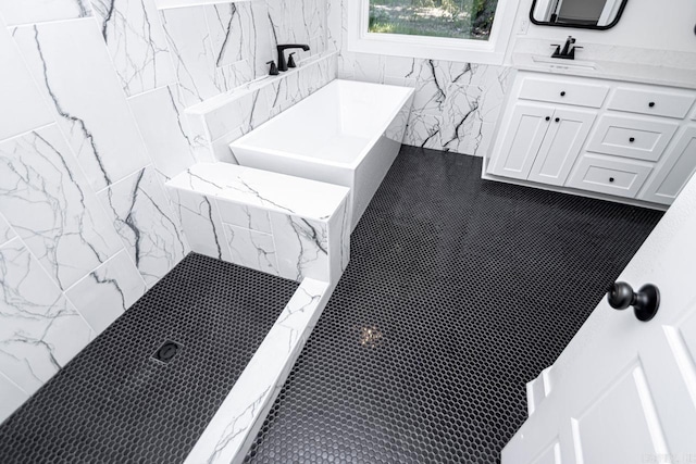 interior space with tiled shower, vanity, and tile patterned floors