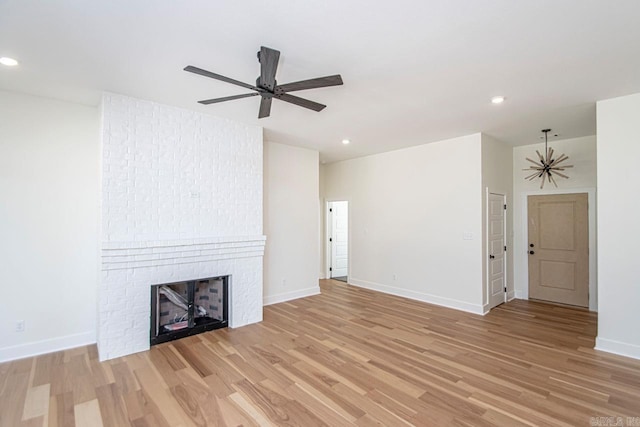 unfurnished living room featuring a fireplace, light hardwood / wood-style flooring, and ceiling fan