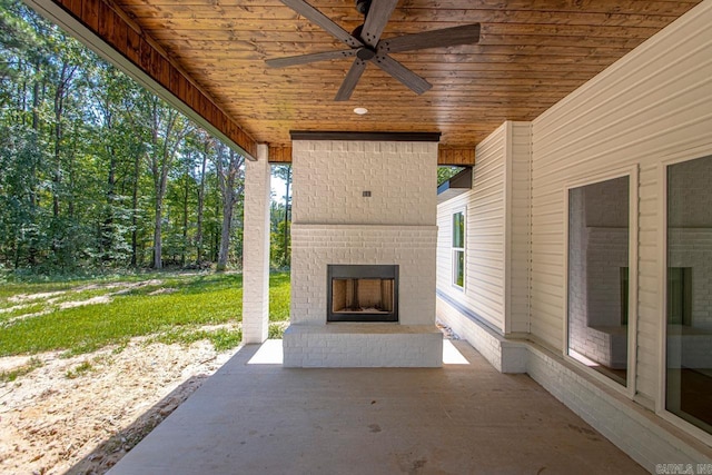 view of patio with an outdoor brick fireplace and ceiling fan