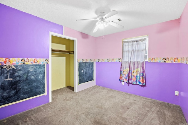 unfurnished bedroom with a textured ceiling, ceiling fan, light carpet, and a closet