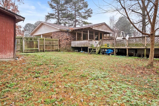 back of house with a deck and a yard