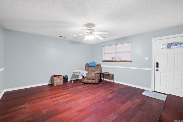 sitting room featuring a textured ceiling, ceiling fan, and dark hardwood / wood-style floors