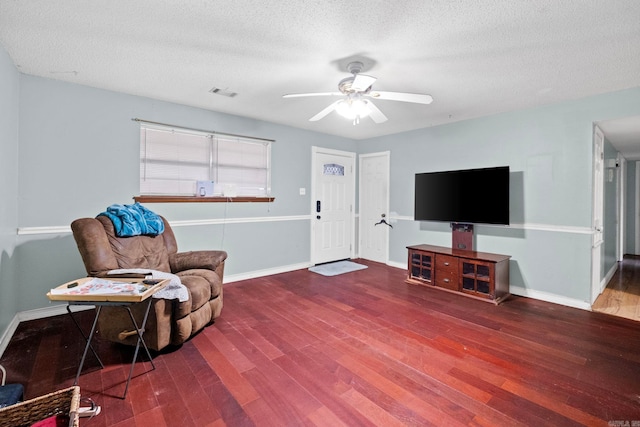 living area with hardwood / wood-style floors, ceiling fan, and a textured ceiling