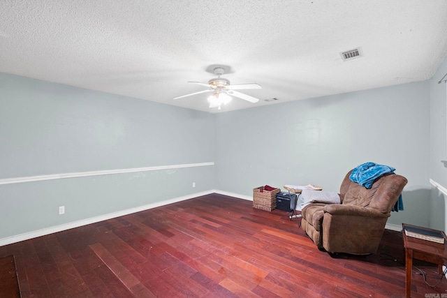 living area featuring a textured ceiling, ceiling fan, and dark hardwood / wood-style floors