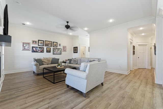 living room featuring ornamental molding, light wood finished floors, and baseboards