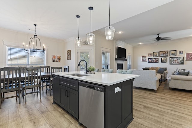 kitchen with dishwasher, open floor plan, a kitchen island with sink, light countertops, and a sink