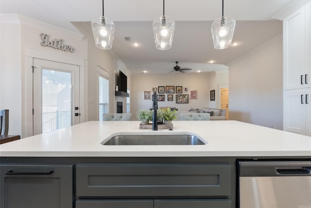 kitchen with light countertops, stainless steel dishwasher, open floor plan, a sink, and an island with sink