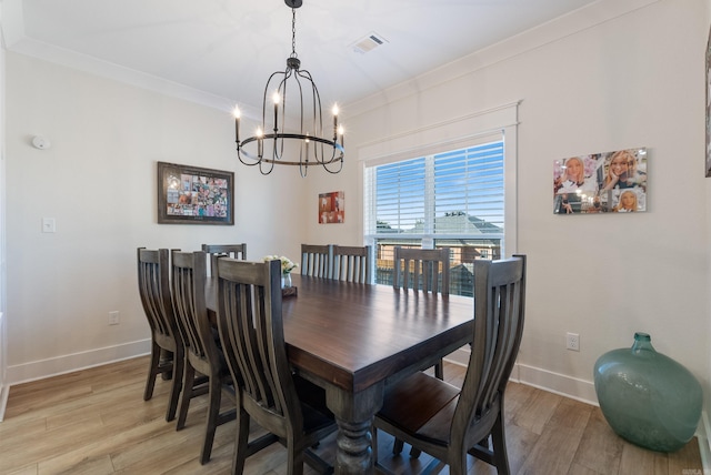 dining room featuring crown molding, a notable chandelier, visible vents, light wood-style flooring, and baseboards