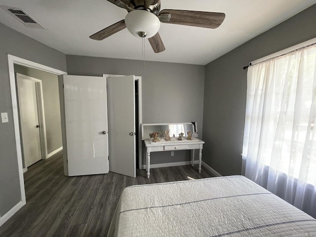 bedroom with multiple windows, ceiling fan, and dark wood-type flooring