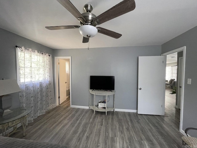 interior space featuring a wealth of natural light, ceiling fan, and dark hardwood / wood-style floors