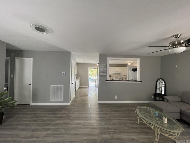 living room with ceiling fan and dark hardwood / wood-style flooring