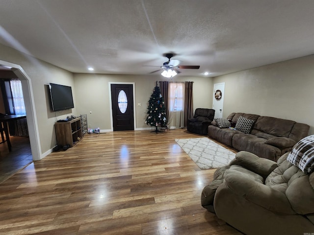 living room with ceiling fan, wood-type flooring, and a textured ceiling