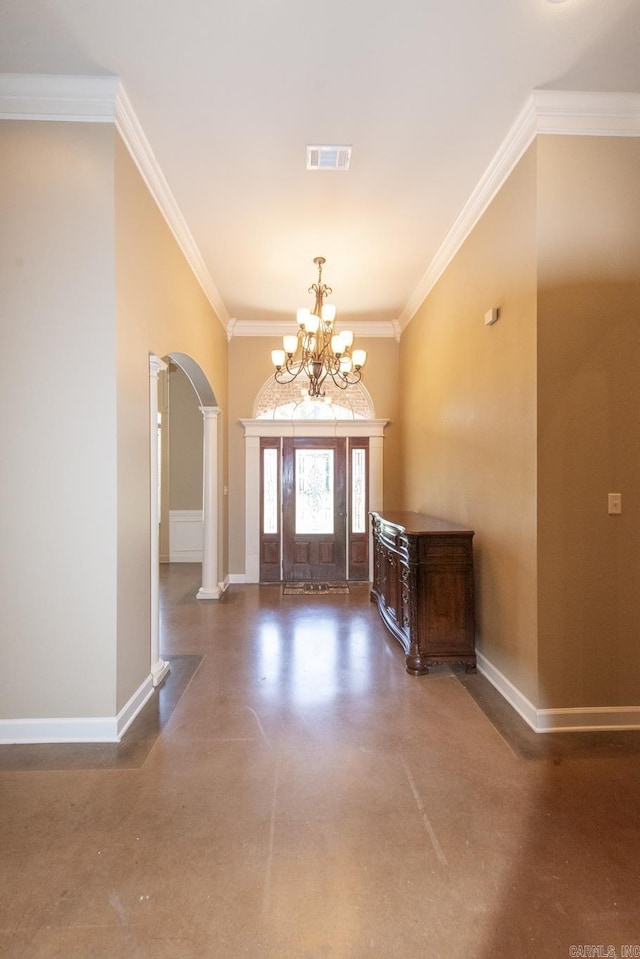 entrance foyer featuring ornate columns, crown molding, and a notable chandelier