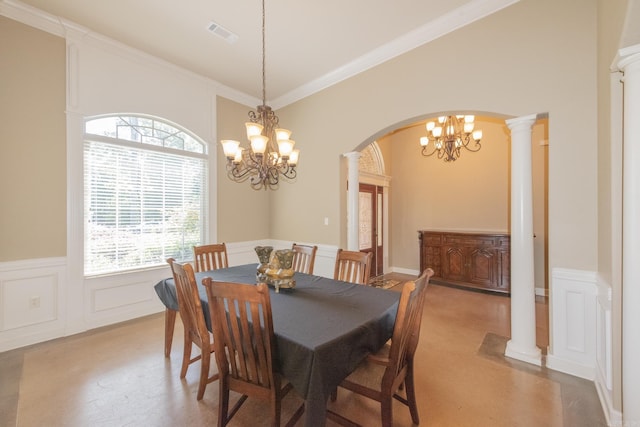 dining room featuring decorative columns, crown molding, and an inviting chandelier