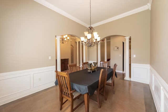 dining area featuring a notable chandelier, crown molding, and decorative columns