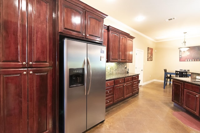 kitchen with dark stone counters, hanging light fixtures, crown molding, stainless steel refrigerator with ice dispenser, and tasteful backsplash