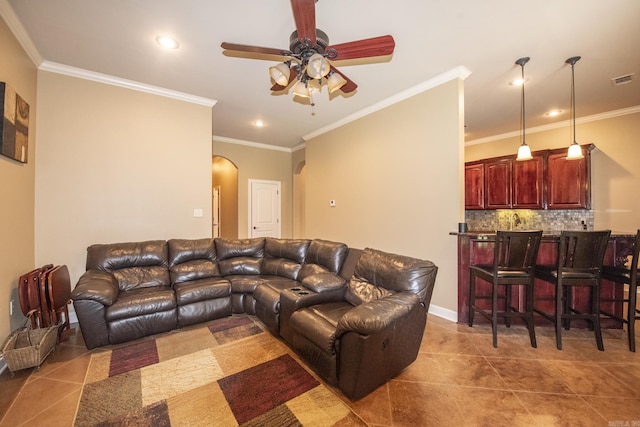 tiled living room with crown molding and ceiling fan