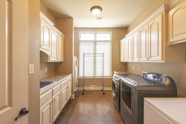 laundry area featuring water heater, washer and clothes dryer, cabinets, and sink