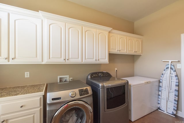 clothes washing area with washer and clothes dryer and cabinets