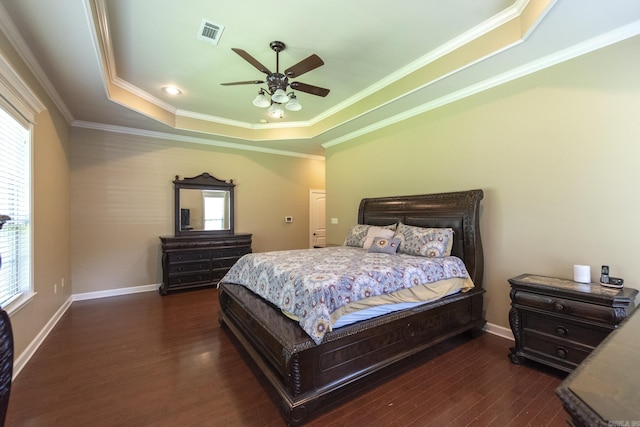 bedroom featuring ceiling fan, dark hardwood / wood-style flooring, multiple windows, and a tray ceiling