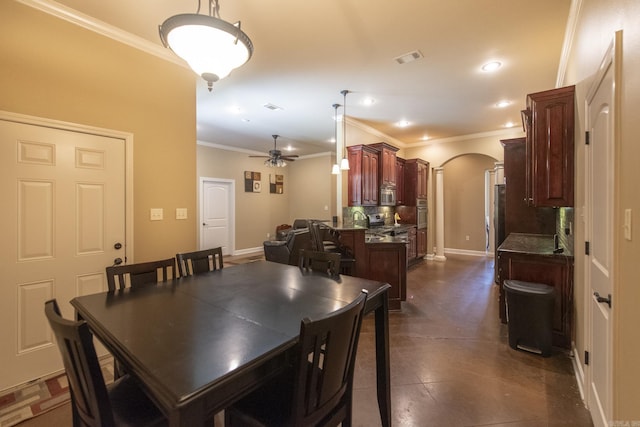 dining space featuring dark tile patterned flooring, ceiling fan, and crown molding