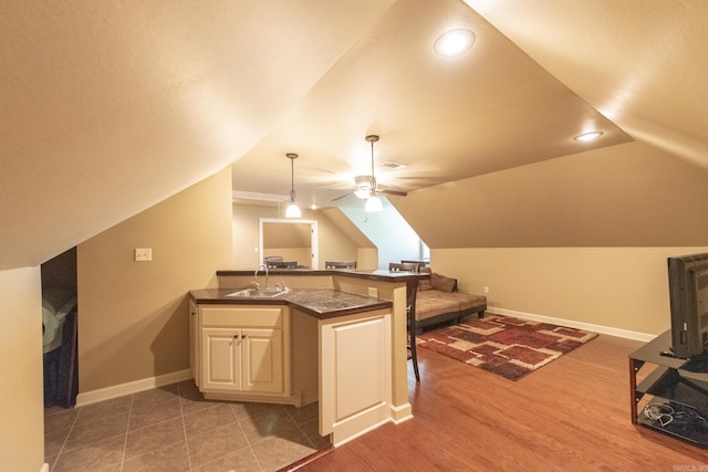 interior space with hardwood / wood-style flooring, ceiling fan, lofted ceiling, and sink