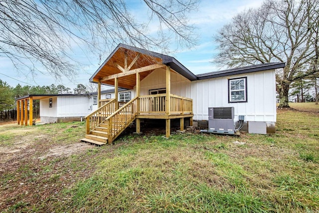 rear view of house with a lawn, central AC, and a deck