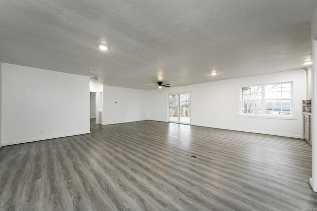 unfurnished living room featuring hardwood / wood-style flooring, ceiling fan, and a textured ceiling