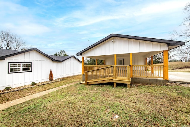 rear view of property featuring covered porch and a yard