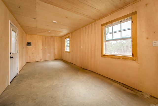 spare room featuring concrete floors, a wealth of natural light, wooden walls, and wood ceiling