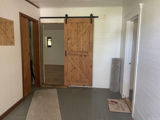 hallway featuring dark hardwood / wood-style floors and a barn door