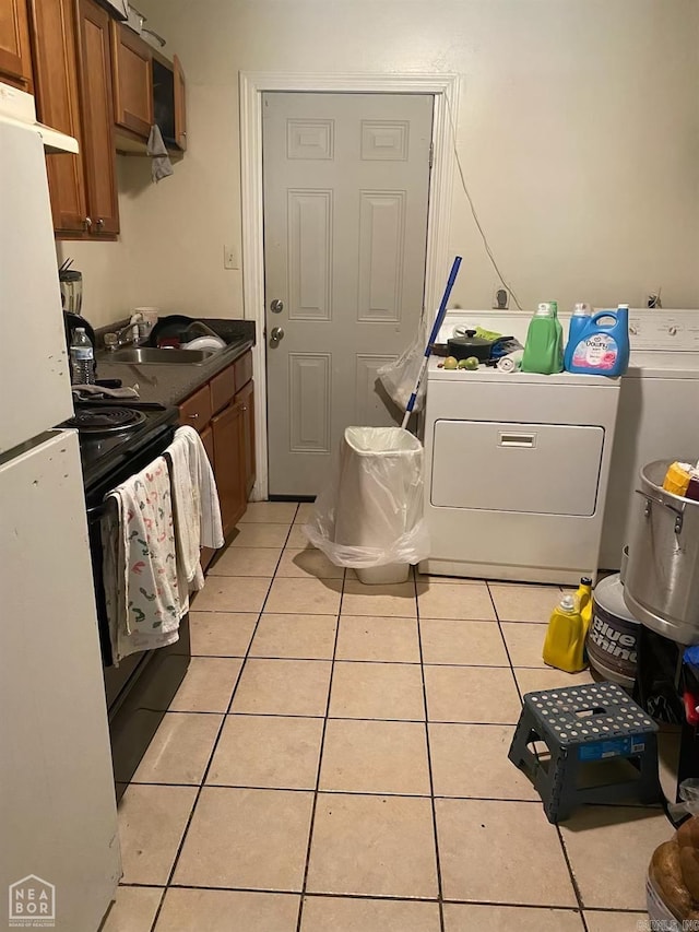 washroom featuring independent washer and dryer, light tile patterned floors, and sink