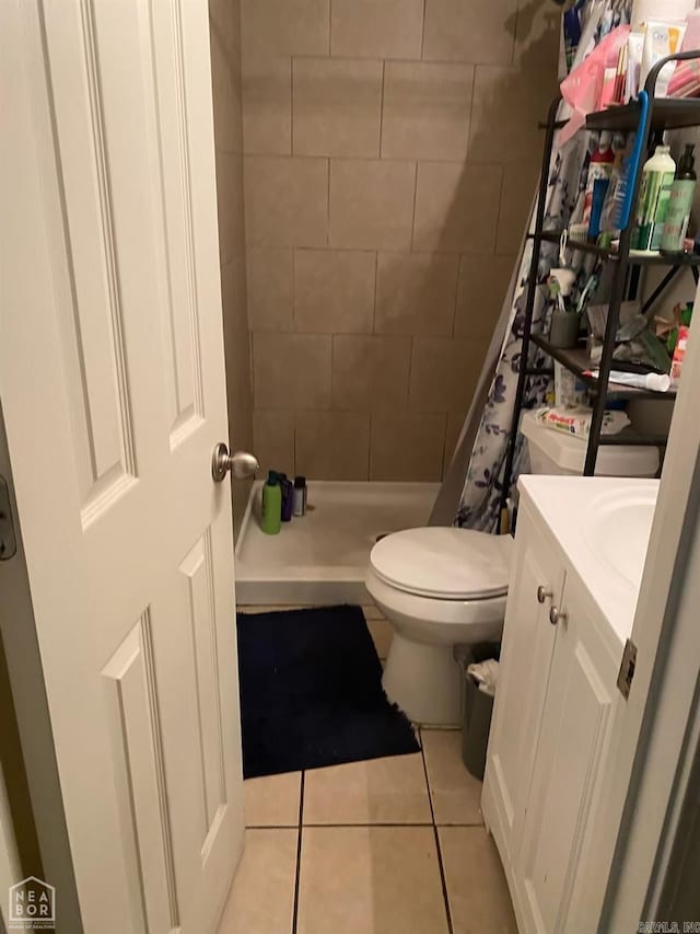 bathroom featuring tile patterned flooring, a shower with curtain, vanity, and toilet