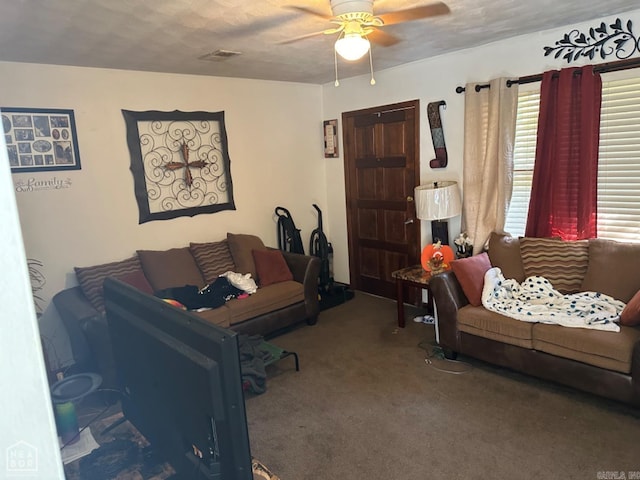 living room with ceiling fan, carpet floors, and a textured ceiling