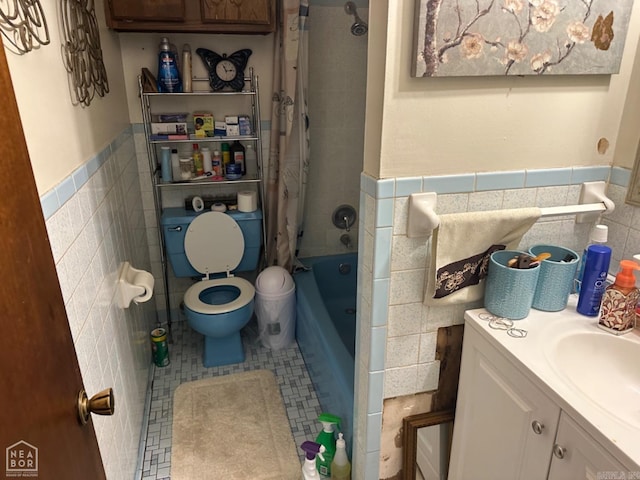 full bathroom featuring shower / bathtub combination with curtain, tile patterned floors, toilet, vanity, and tile walls