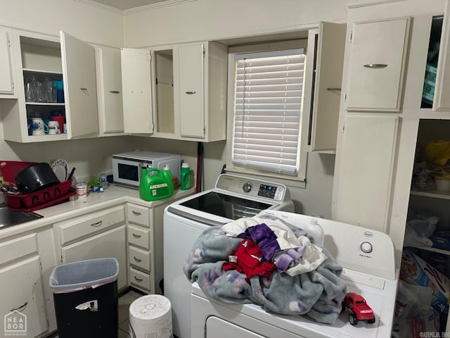 laundry area with sink, washer and clothes dryer, cabinets, and ornamental molding