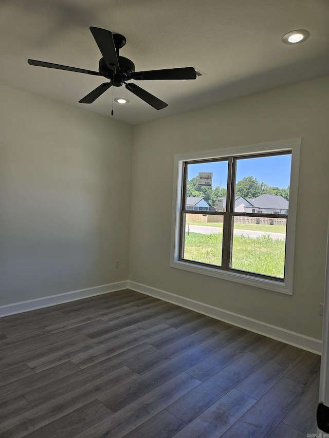 spare room with dark hardwood / wood-style flooring and ceiling fan