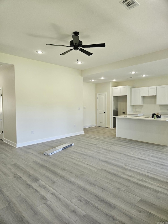 unfurnished living room featuring ceiling fan and light hardwood / wood-style flooring