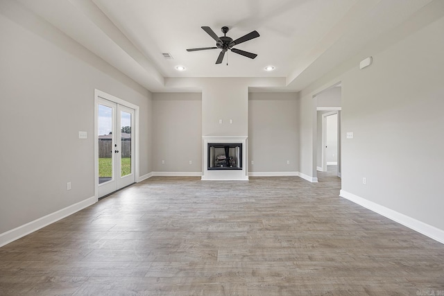 unfurnished living room featuring french doors, ceiling fan, and wood-type flooring