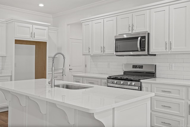 kitchen featuring white cabinetry, light stone counters, a kitchen island with sink, a breakfast bar, and appliances with stainless steel finishes