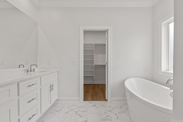 bathroom featuring a bathing tub, a wealth of natural light, crown molding, and vanity