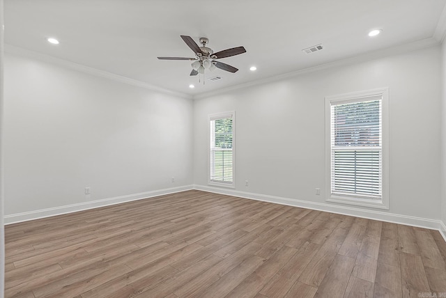 spare room featuring crown molding, ceiling fan, a healthy amount of sunlight, and light wood-type flooring