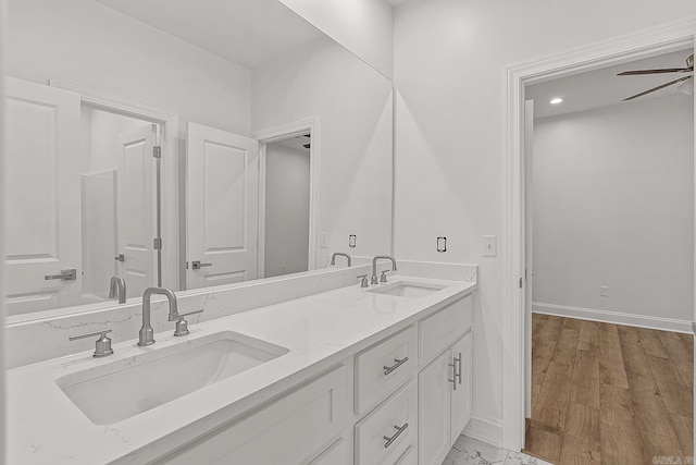 bathroom with wood-type flooring, vanity, and ceiling fan