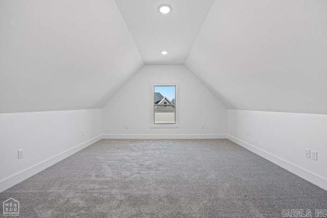 additional living space with carpet flooring and vaulted ceiling